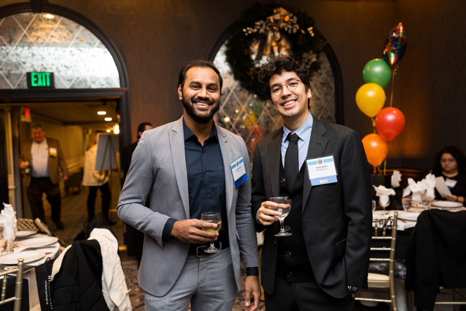 Two men smiling at a social event.