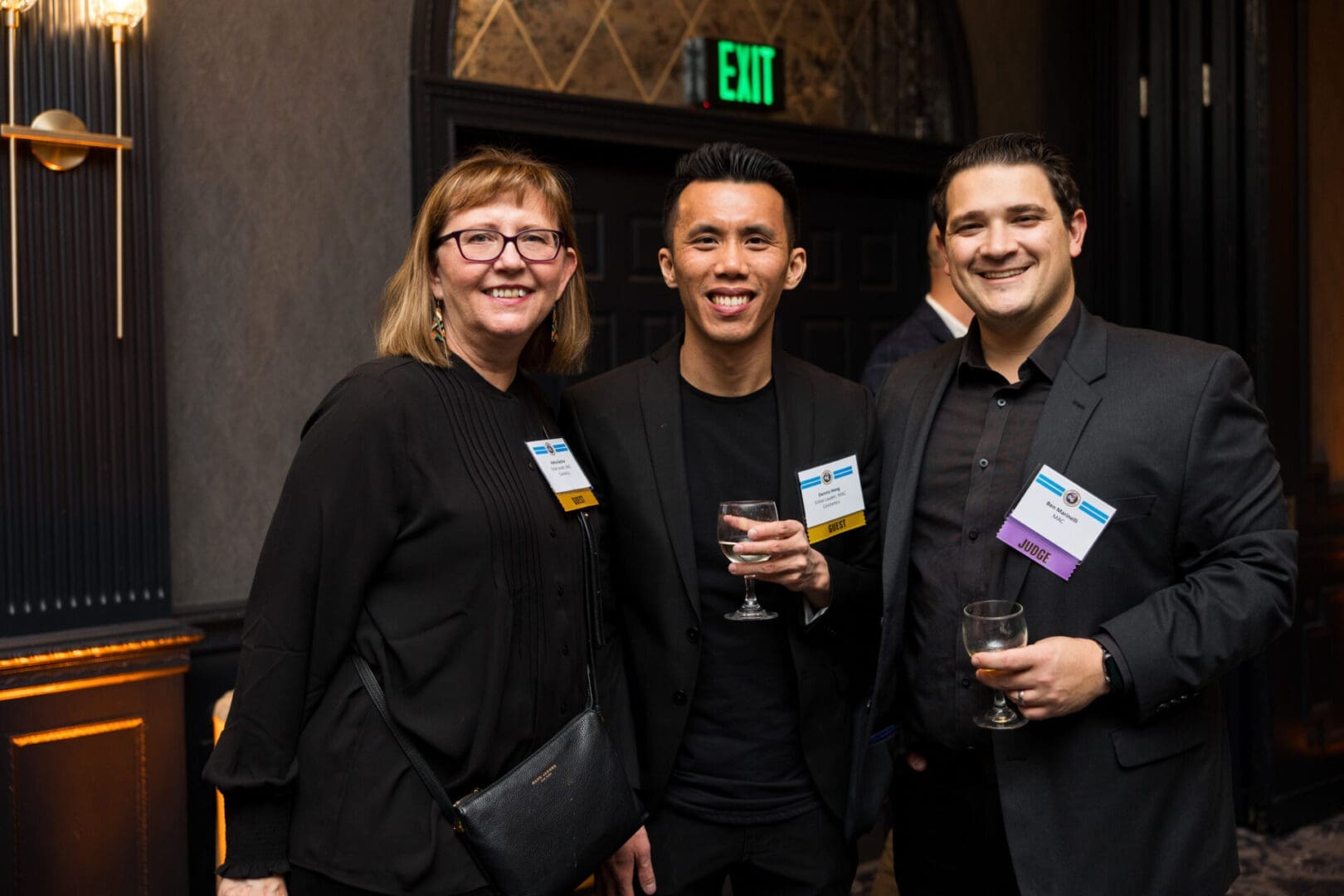 Three people smiling at an event gathering.