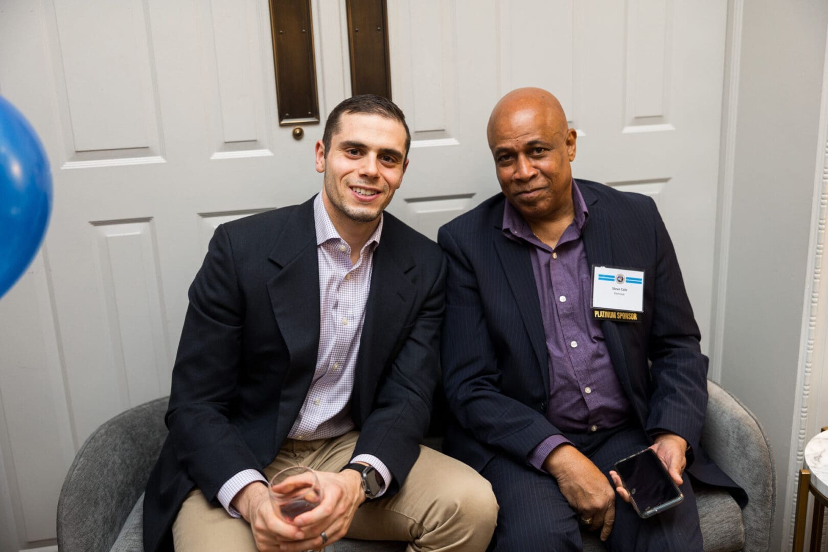 Two men sitting together, smiling and relaxed.