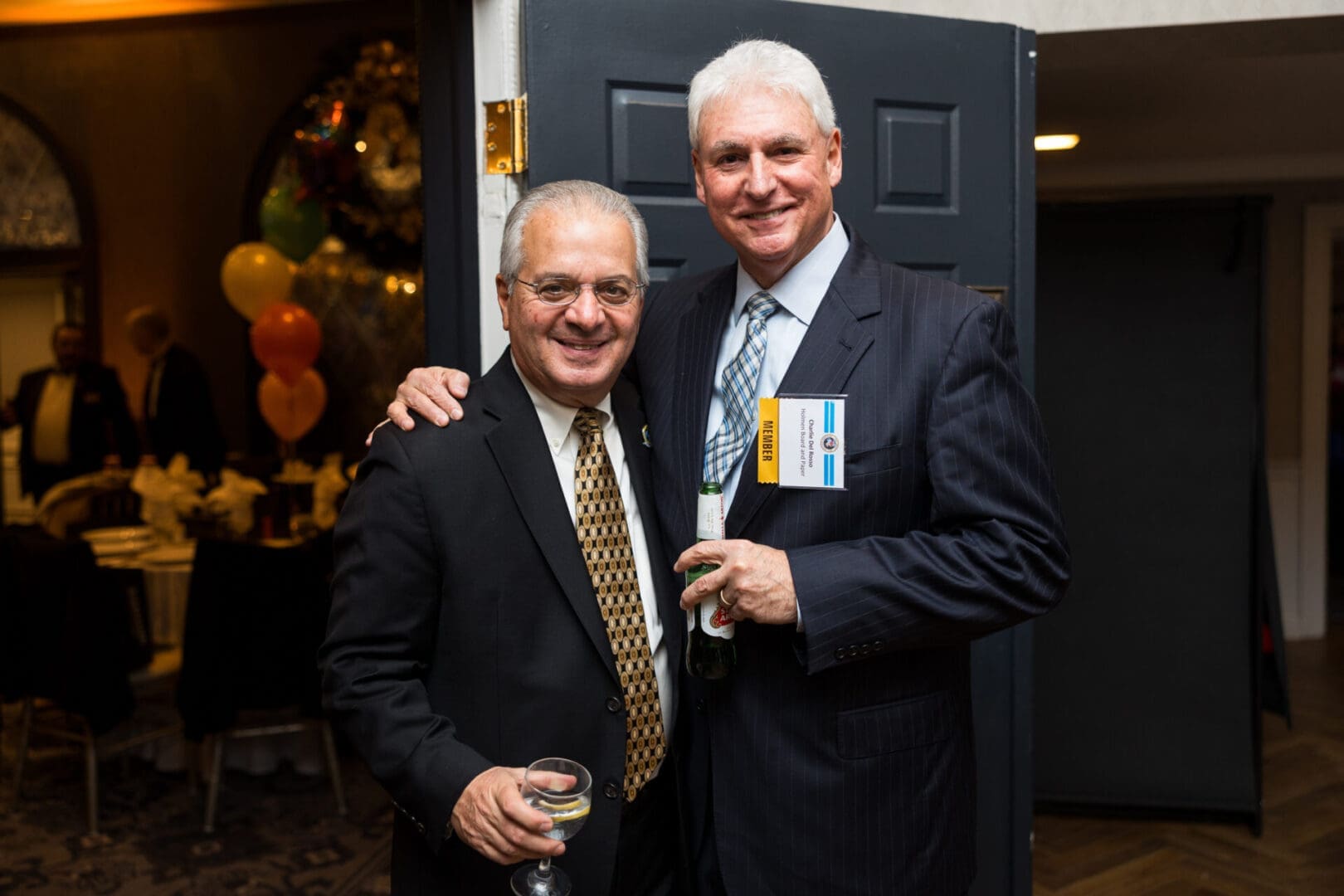 Two men smiling at a social event.