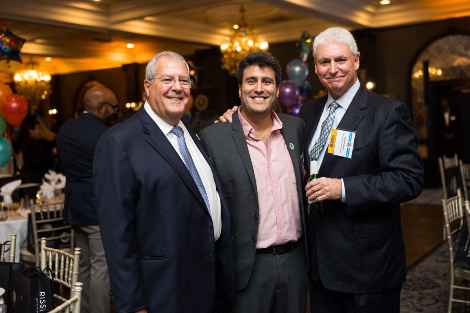 Three men smiling at a festive event.