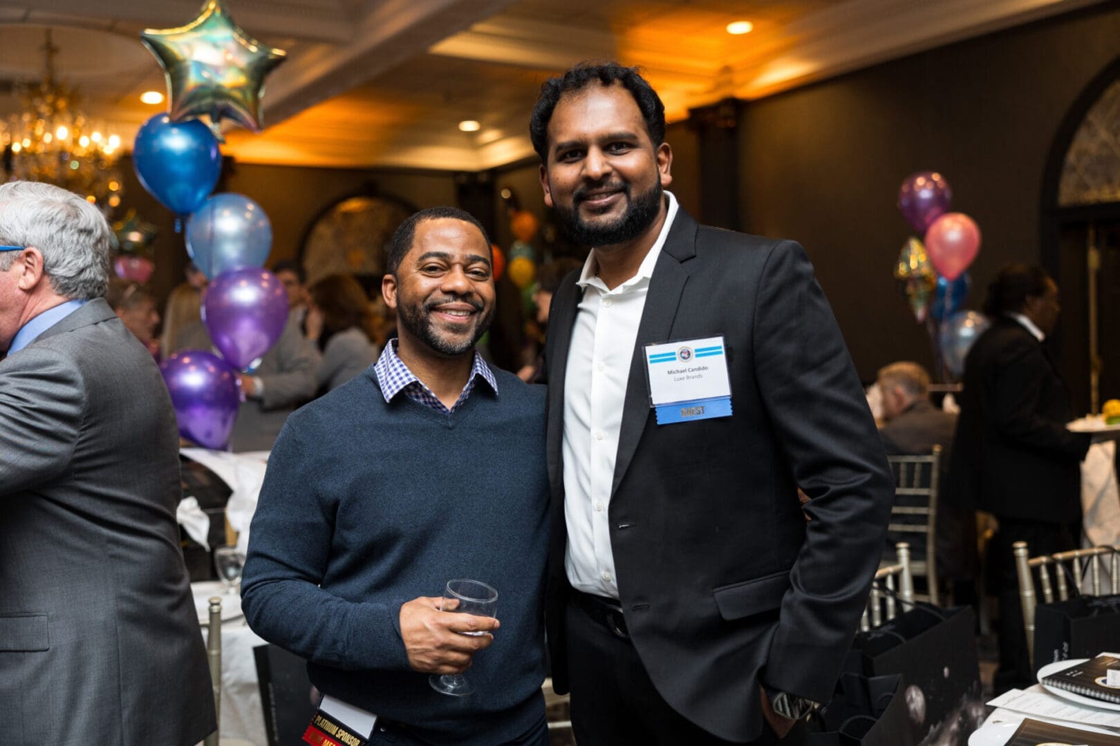 Two men smiling at a festive event.
