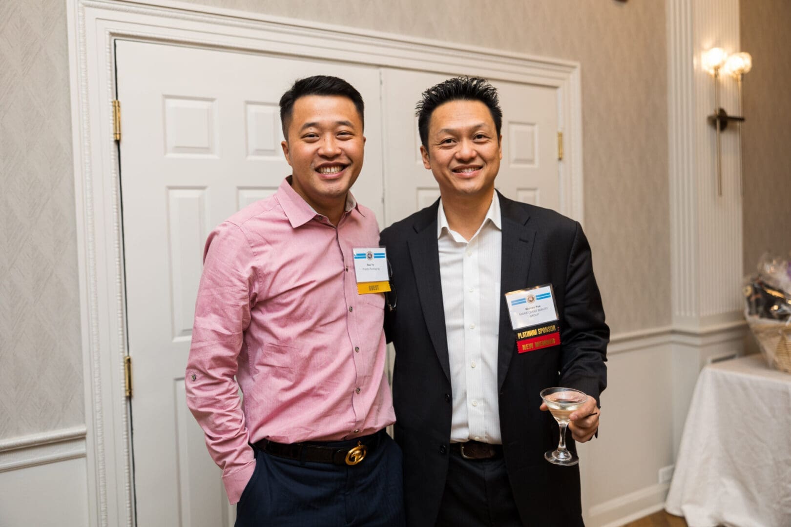 Two men smiling at a social event.