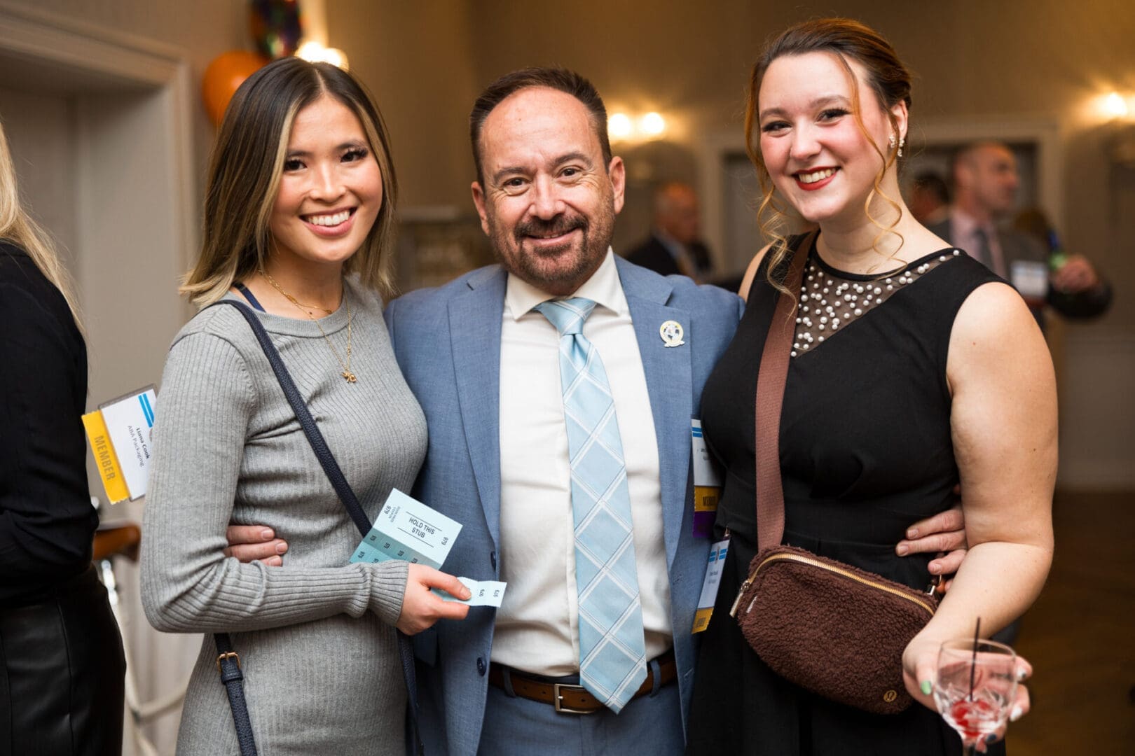 Three people smiling at an event.