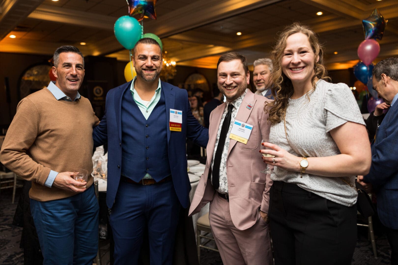 Four people posing at a festive event.