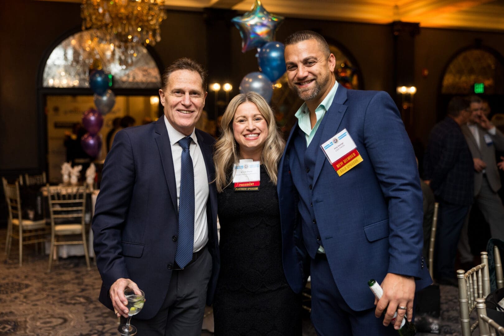Three professionals posing at an event.