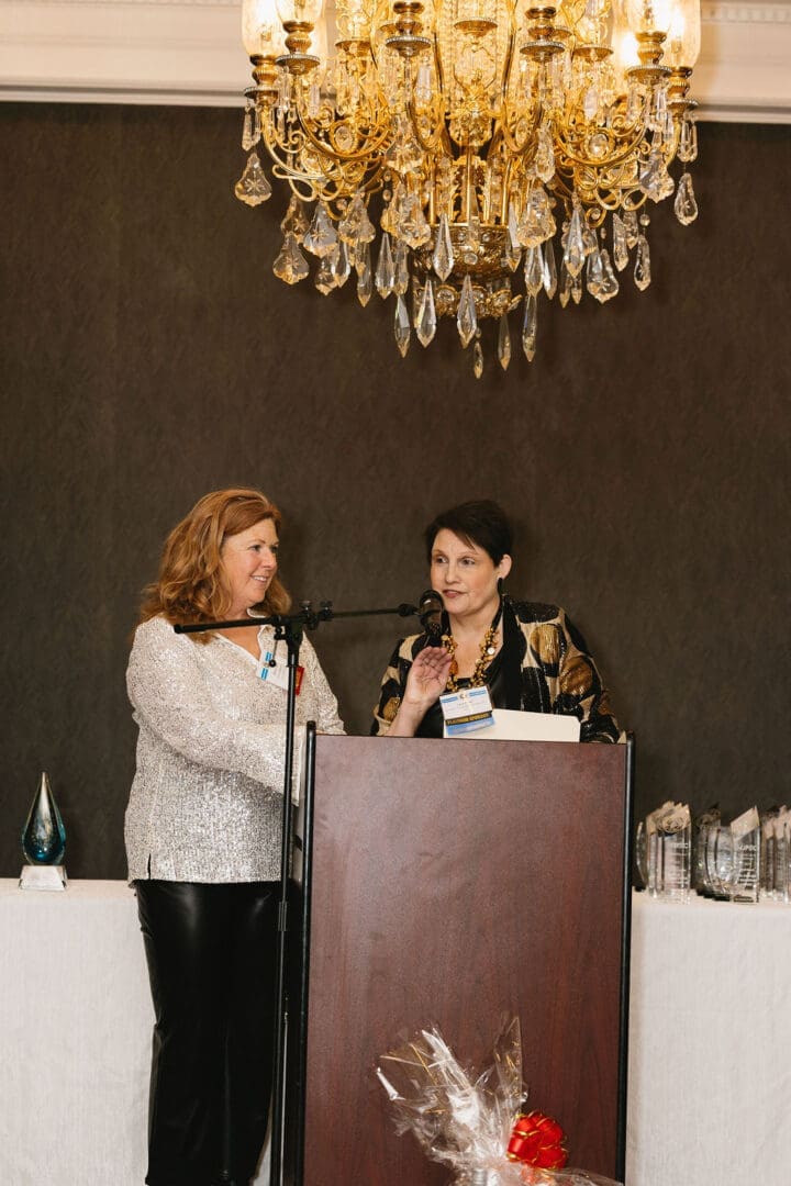 Two women speaking at a podium event.
