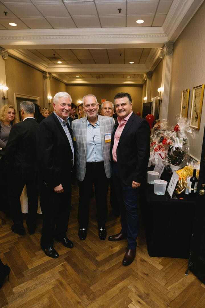 Three men posing at a formal event.