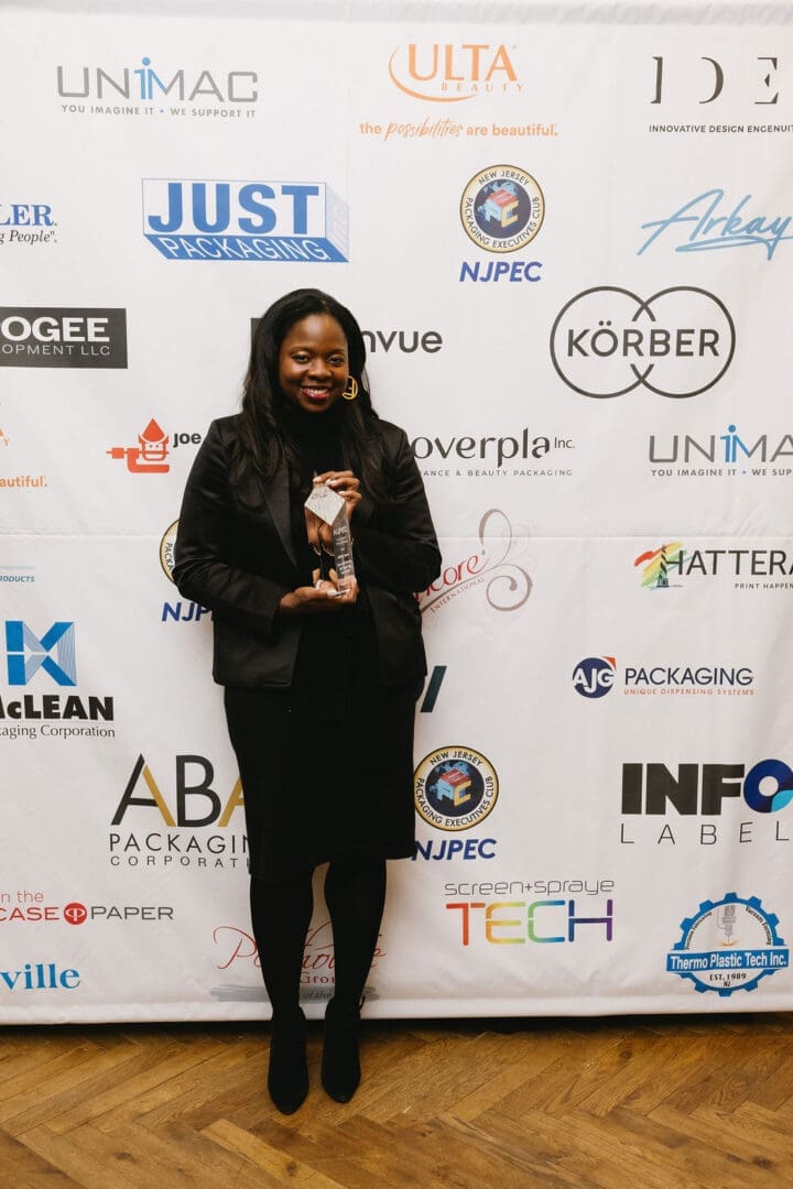 Person holding an award, standing on stage.