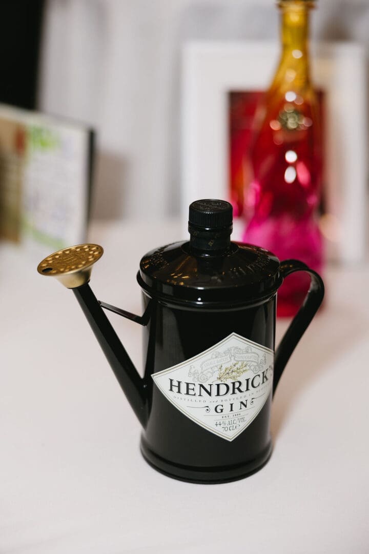 Black watering can with Hendrick's Gin label.